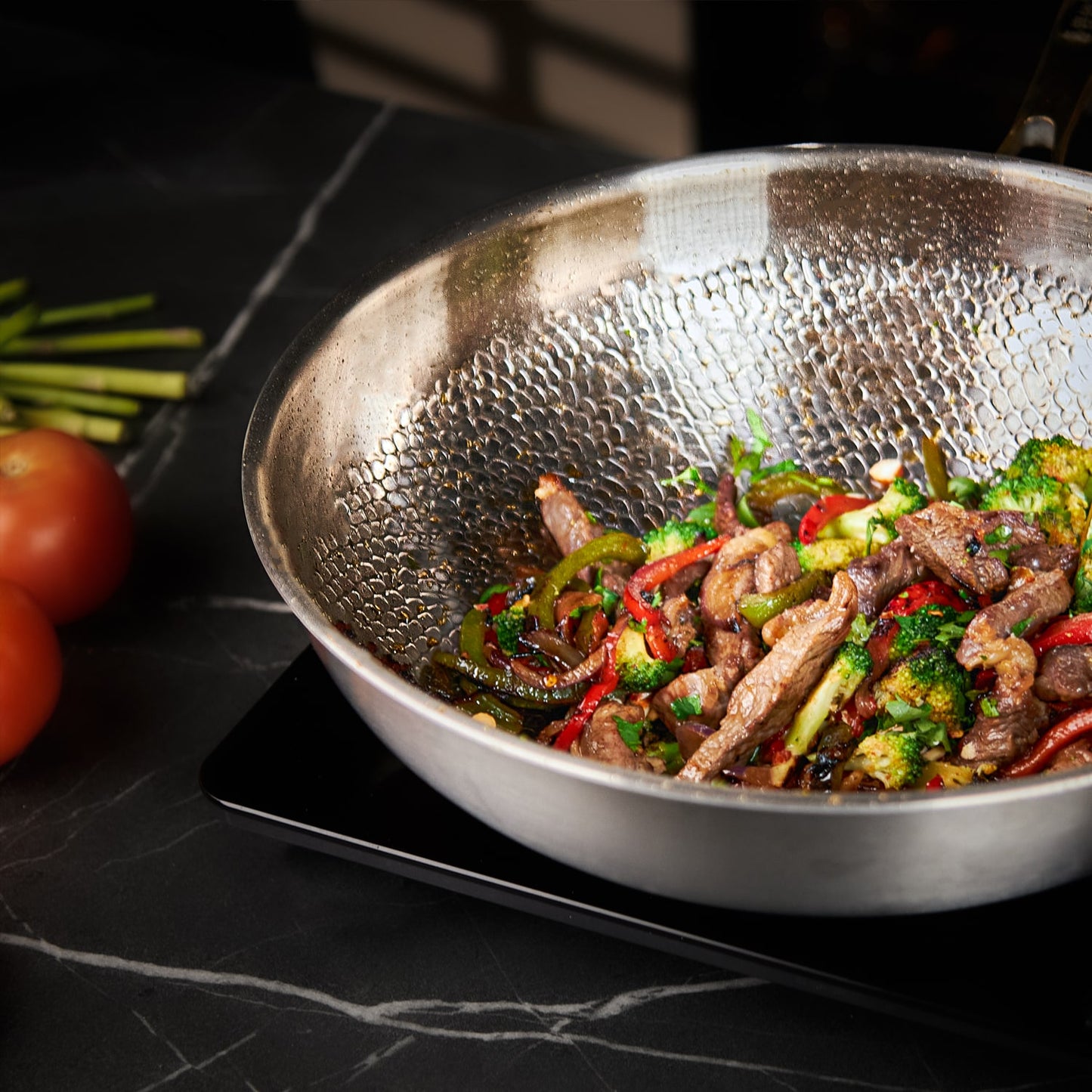 Stir-fry dish with beef and vegetables in a wok on a dark surface