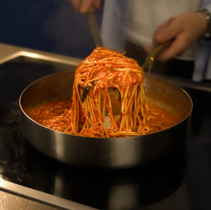 Spaghetti being stirred in a pan